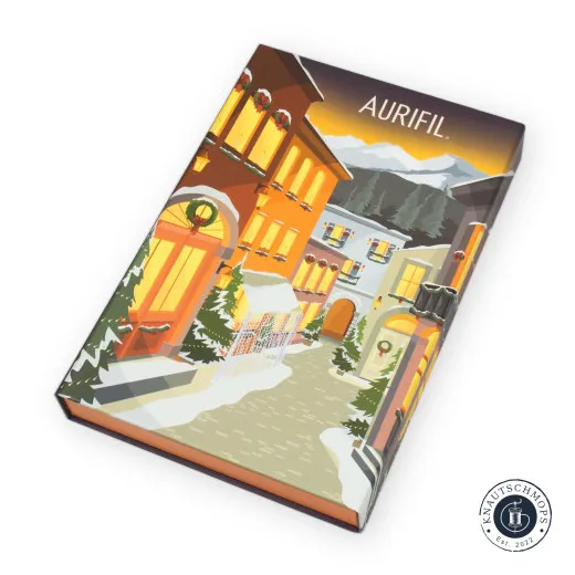 Aurifil Adventskalender - Verpackung Geschlossene Aurifil „Il Borgo"-Adventskalenderbox mit illustriertem Alpendorf-Motiv im Winterabendlicht.