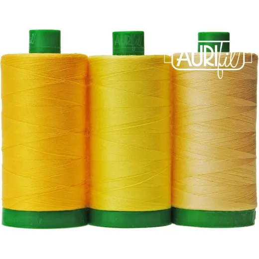Aurifil Color Builder African Wild Dog - Garnrollen Drei Aurifil-Garnrollen des Color-Builder-Sets African Wild Dog in Gelbtönen, freigestellt auf weißem Hintergrund