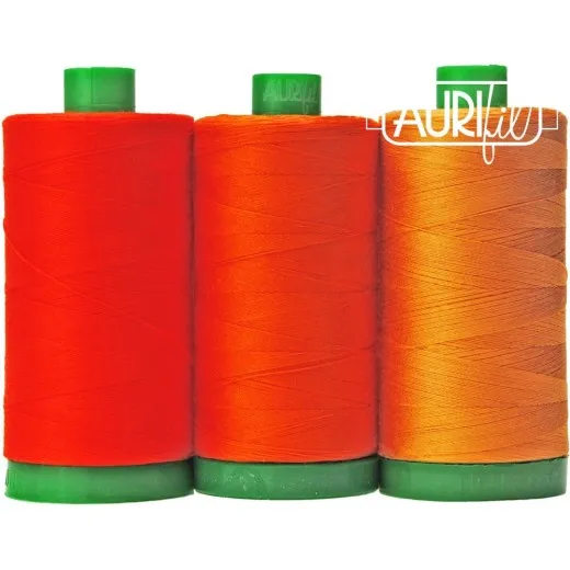 Drei Aurifil-Garnrollen des Color-Builder-Sets Sumatran Tiger in Orangetönen, freigestellt auf weißem Hintergrund