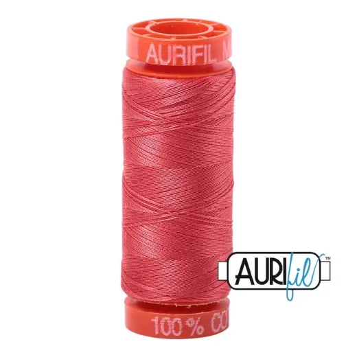 Orangefarbene Aurifil-Garnspule mit 50wt-Baumwollgarn in der Farbe Medium Red (Korallenrot) vor weißem Hintergrund.