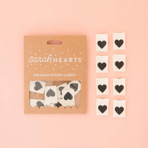 Black Heart – Verpackung Verpackung der Sarah Hearts Weblabels „Black Heart" mit schwarzem Herz auf cremefarbenem Bio-Baumwollstoff
