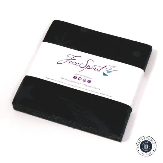 Gestapelter Tula-Pink-Charm-Pack „Linework – Fairy Flakes" in Schwarz mit Sternschnuppen-Muster, mit FreeSpirit-Banderole, schräg fotografiert.