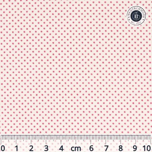 Flach ausgebreiteter Tilda-Stoff „Classic Basics – Tiny Dots“ in Pink mit kleinem Punktmuster auf cremefarbenem Grund, mit Lineal zur Maßstabsorientierung.