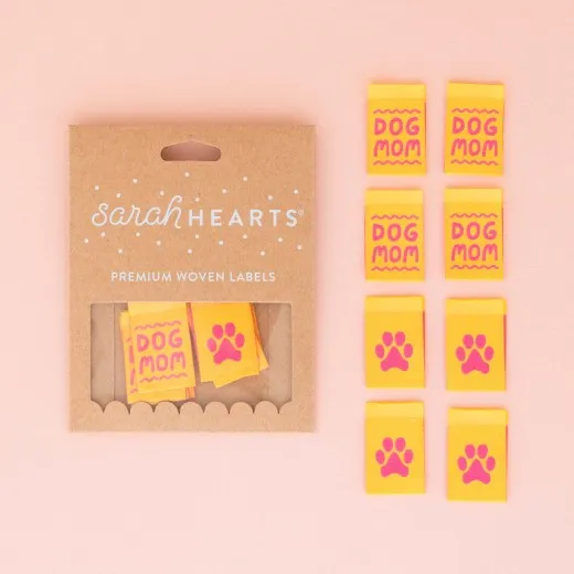 Verpackung der Sarah Hearts Weblabels „Dog Mom" in Gelb mit Schriftzug und Pfotenabdruck