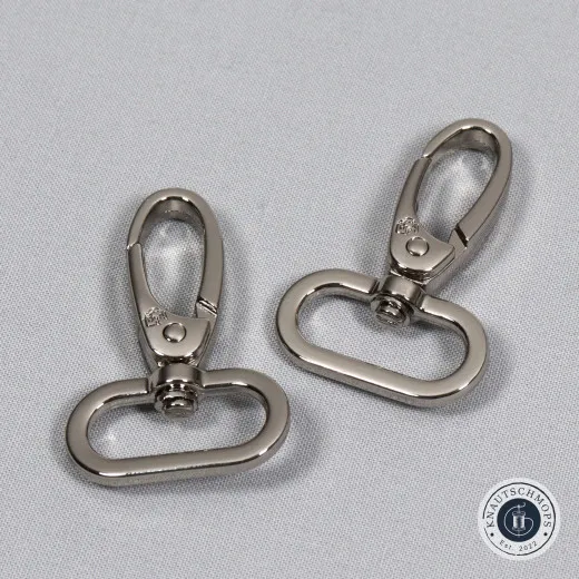 Drehkarabinerhaken Nickel Zwei ByAnnie's Drehkarabinerhaken in Nickel auf grauem Stoffuntergrund