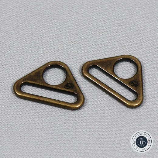 Dreiecksring Antique Brass Zwei ByAnnie's Dreiecksringe (Triangle Rings) in Antique Brass auf grauem Stoffuntergrund