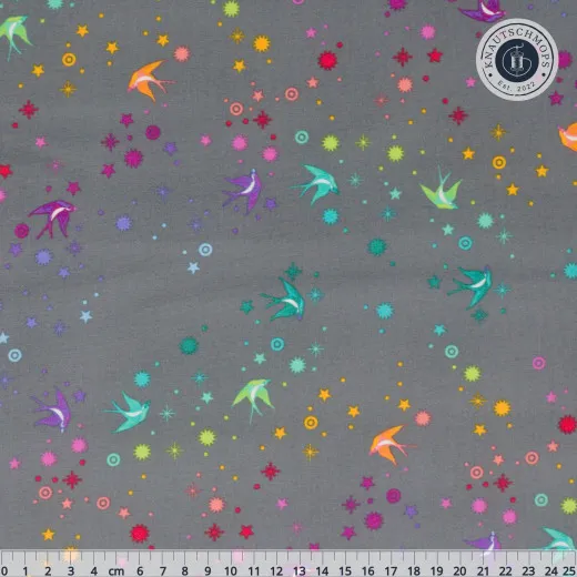 Fairy Dust Shadow – Musterdetail Tula-Pink-Stoff Fairy Dust in Shadow: bunte Schwalben und Sterne auf dunkelgrauem Fond, Musterausschnitt mit Lineal (25cm)