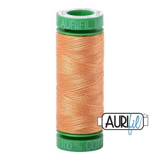 Garnrolle Golden Honey Aurifil-Garnrolle mit grünen Endkappen, bespult mit honigfarbenem, warm-orangem Baumwollgarn.