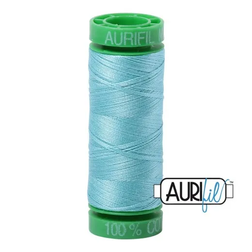 Garnrolle Light Turquoise Aurifil-Garnrolle mit grünen Endkappen und hellem, türkisblauem Baumwollgarn.