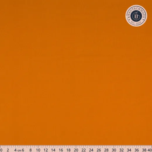 Nahaufnahme des orangen Baumwollstoffs Gingerbread mit Lineal bis 40 cm