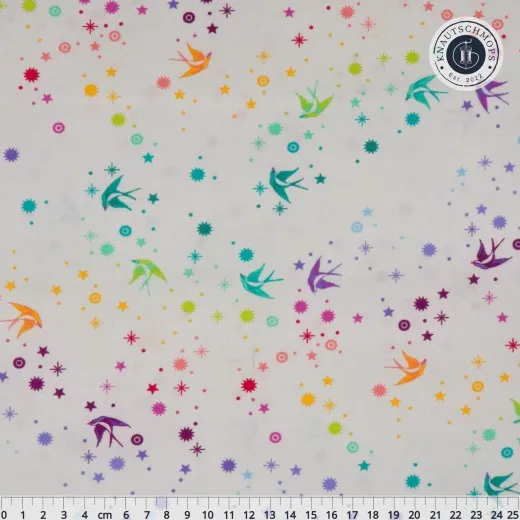 Nahaufnahme des True-Colors-Stoffs „Fairy Dust" in Whisper mit fliegenden Schwalben und Sternen auf hellem Fond, mit Zentimetermaß.