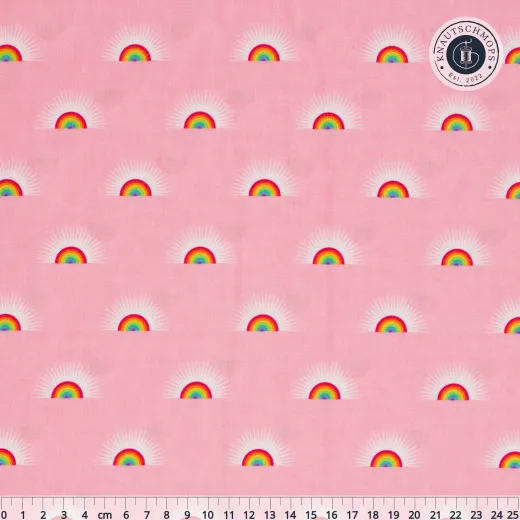 Flach ausgebreiteter Baumwollstoff „Sundaze“ in Guava mit Zentimeter-Maßstab: Regenbogen-Motiv mit Sonnenstrahlen auf Rosa.