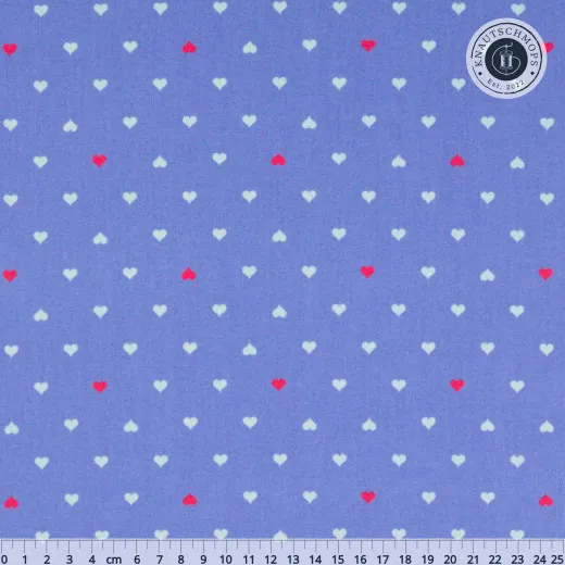 Musterausschnitt mit Maßstab Flach ausgebreiteter Baumwollstoff „Unconditional Love“ in Bluebell mit Zentimeter-Maßstab: Herzchen-Muster in Weiß und Rot auf Kornblumenblau.