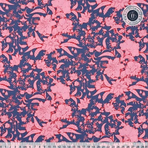 Nahaufnahme des Bloomsville-Musters „Abloom" mit großen Blütenranken in Rosa auf Prussian-Blau, mit Maßband.