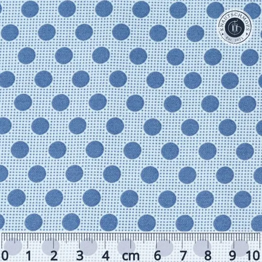 Nahaufnahme des Tilda-Musters „Basic Dots" in Denim Blue mit taubenblauen, ca. 7mm großen Punkten auf hellblauem Fond, mit Maßband zum Größenvergleich.