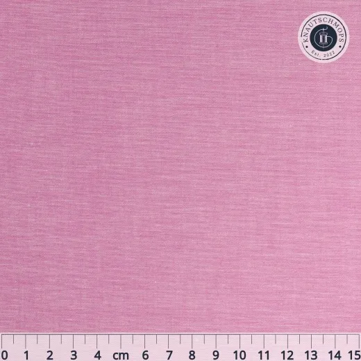 Nahaufnahme des unifarbenen Chambray-Stoffs in Cerise-Pink mit Maßband.