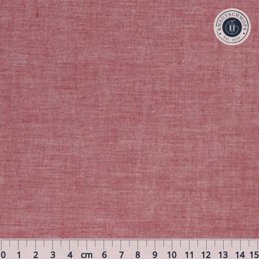 Nahaufnahme des unifarbenen Chambray-Stoffs in Rot mit Maßband.