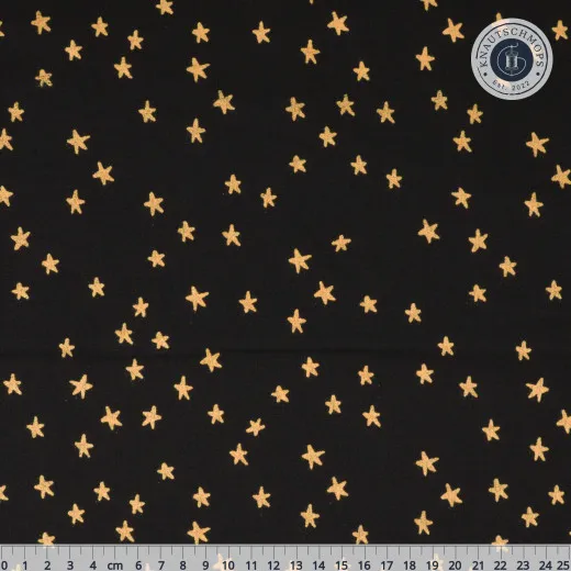 Ruby Star Society Blenders Star Starry Metallic Black Gold Schwarzer Baumwollstoff mit goldfarbenen Metallic-Sternen, mit Zentimeter-Maßstab am unteren Bildrand.