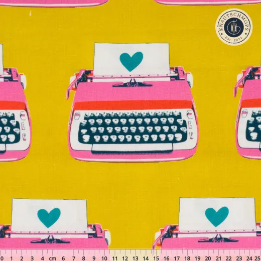 Ruby Star Society Canvas Best Day Ever Typewriters Golden Gelber Canvas-Stoff mit rosafarbenen Retro-Schreibmaschinen und türkisfarbenen Herzen, mit Zentimeter-Maßstab am unteren Bildrand.