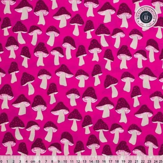 Pinkfarbener Baumwollstoff mit violetten, gepunkteten Pilzmotiven und cremefarbenen Stielen, mit Zentimeter-Maßstab am unteren Bildrand.