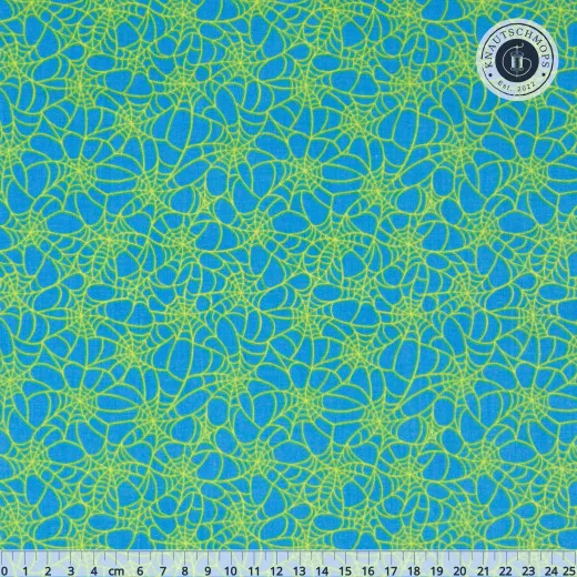 Blauer Baumwollstoff mit gelbgrünem Spinnennetz-Muster, mit Zentimeter-Maßstab am unteren Bildrand.