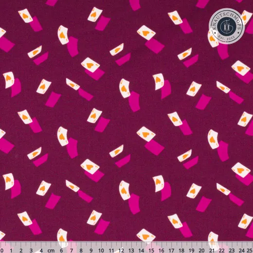 Violetter Baumwollstoff mit fallenden Herz-Ass-Spielkarten in Pink und Creme, mit Zentimeter-Maßstab am unteren Bildrand.