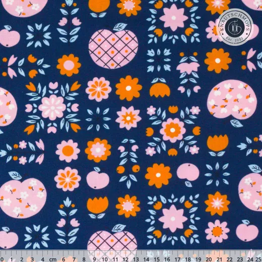 Marineblauer Baumwollstoff mit Folk-Art-Muster aus Äpfeln und Blüten in Pink, Orange und Hellblau, mit Zentimeter-Maßstab am unteren Bildrand.
