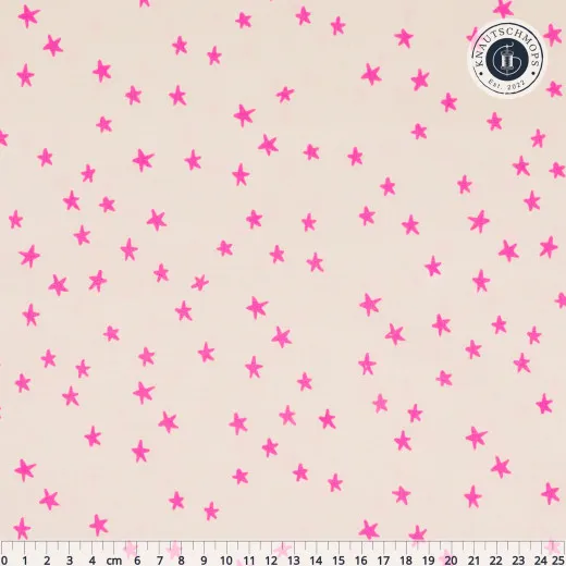 Cremefarbener Baumwollstoff übersät mit kleinen pinkfarbenen Sternen, mit Zentimeter-Maßstab am unteren Bildrand.