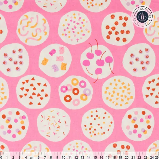 Pinkfarbener Baumwollstoff mit cremefarbenen Kreisen, gefüllt mit bunten Eis-Toppings wie Streuseln, Kirschen, Gummibärchen und Krokant, mit Zentimeter-Maßstab am unteren Bildrand.