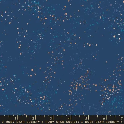 Speckled Bluebell – Musternahaufnahme Nahaufnahme des Ruby Star Society Speckled Stoffs in Bluebell: dunkelblauer Fond mit lachsfarbenen und türkisen Farbsprenkeln, Marken-Maßband zeigt die Musterdichte.