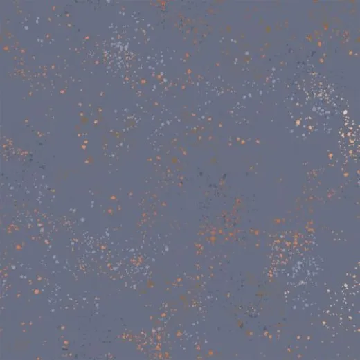 Speckled Denim – Stoffdetail Nahaufnahme des melierten Baumwollstoffs Speckled in Denim mit kupferfarbenen und hellblauen Farbspritzern auf graublauem Grund.