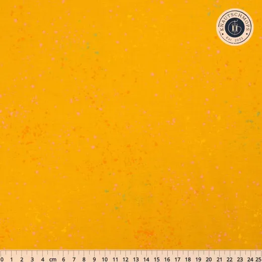 Ruby Star Society Speckled Stoffmuster in Goldenrod: goldgelber Fond mit bunten Farbtupfern in Pink, Orange und Mint, flach ausgebreitet mit Zentimeter-Maßband.