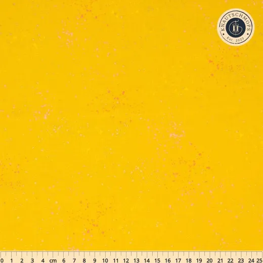 Ruby Star Society Speckled Stoffmuster in Metallic Golden Hour: goldgelber Fond mit goldfarbenen Metallic-Tupfern und rosa Farbakzenten, flach ausgebreitet mit Zentimeter-Maßband.