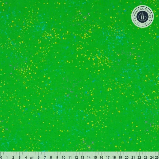 Ruby Star Society Speckled Stoffmuster in Verdant: grasgrüner Fond mit bunten Farbtupfern in Gelb, Türkis und Lavendel, flach ausgebreitet mit Zentimeter-Maßband.