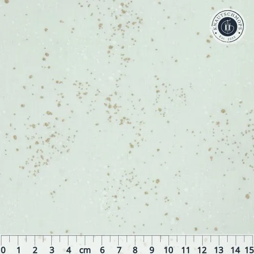 Nahaufnahme des Ruby Star Society Speckled Stoffs in White Gold: zartes Mint-Weiß mit goldenen und weißen Farbsprenkeln, Maßband zeigt die Musterdichte.