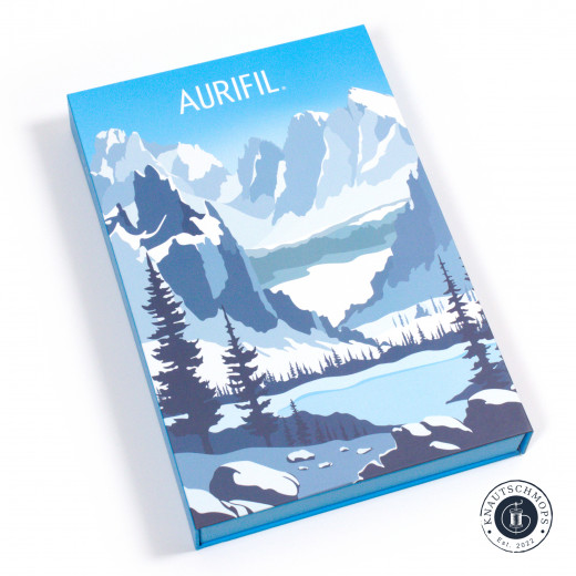 Verpackung Adventskalender Geschlossene Aurifil-Adventskalender-Box „Le Alpi" mit blauem Alpenmotiv aus Bergen, Tannen und See.