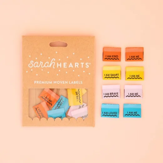 Verpackung der Sarah Hearts Weblabel „Affirmations" mit vier Farbpaaren „I AM KIND", „I AM SMART", „I AM BRAVE" und „I AM LOVED", jeweils mit „I AM ME"-Gegenstück.