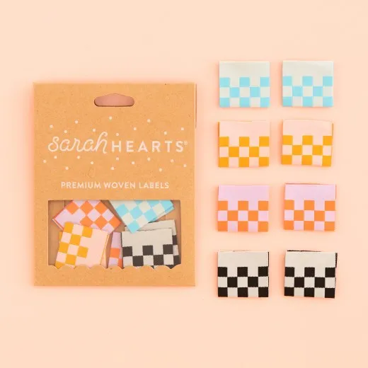 Verpackung Checkerboard Labels Sarah Hearts Verpackungskarton mit 8 Karo-Weblabels in vier Farbkombinationen: Hellblau, Gelb-Rosa, Orange-Flieder und Schwarz-Grau.