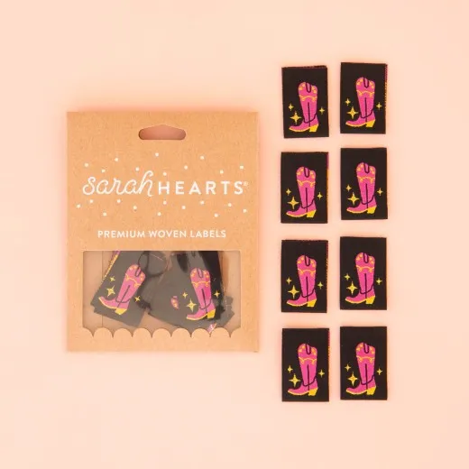 Verpackung Cowboystiefel-Label Verpackung der Sarah Hearts Weblabel „Cowboystiefel" mit acht schwarzen Labels und pink-goldenem Stiefel-Motiv.