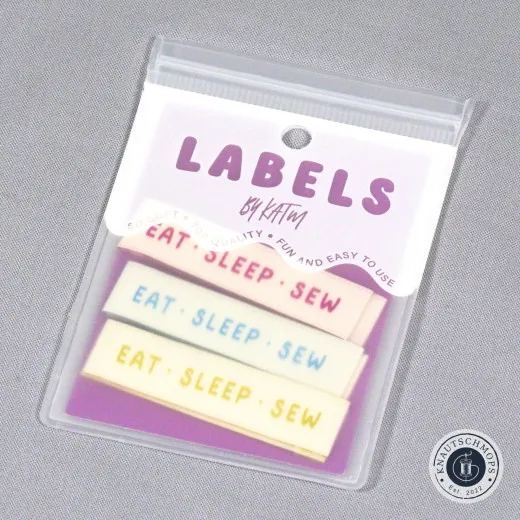 Verpackung der Kylie and The Machine Endfalz-Labels 'Eat Sleep Sew' in Rosa, Mint und Gelb.