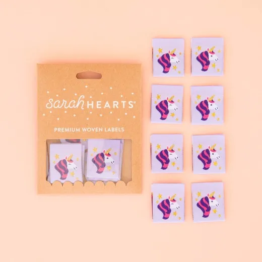 Verpackung Einhorn-Label 8er Set Verpackung der Sarah Hearts Weblabel „Einhorn" mit acht lila Labels und Einhornkopf in Lila und Rosa mit Goldakzent.