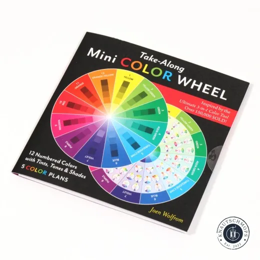 Verpackung des Take-Along Mini Color Wheel mit aufgedrucktem Farbkreis, schräg liegend fotografiert.