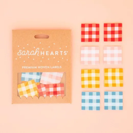 Verpackung der Sarah Hearts Weblabel „Gingham" mit acht karierten Labels in Rot, Rosa, Gelb und Blau.