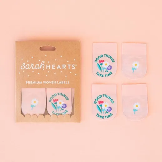 Verpackung der Sarah Hearts Weblabel „Good Things Take Time" mit vier lasergeschnittenen Labels, Blumenstrauß-Motiv und einfacher Gänseblümchen-Rückseite.