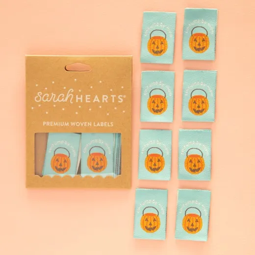 Kraftpapier-Verpackung der Sarah Hearts Weblabels "Costume by Mom" mit orangefarbenem Kürbiseimer-Motiv auf mintgrünem Hintergrund.