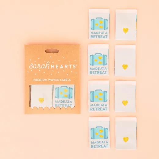 Verpackung der Sarah Hearts Weblabel „Made at a Retreat" mit Koffer-Motiv und goldenem Herz als Rückseiten-Design.