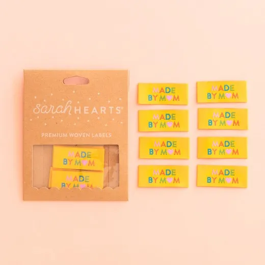 Kraftpapier-Verpackung der Sarah Hearts Weblabels "Made by Mom" in Gelb mit buntem Herz-Schriftzug.