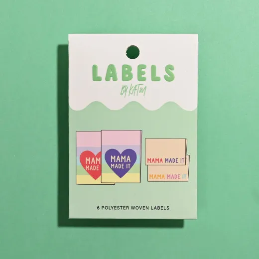 Verpackung der Kylie and The Machine Label 'Mama Made It' mit Herz-Mittelfalzlabels und Seitennahtlabels auf grünem Hintergrund