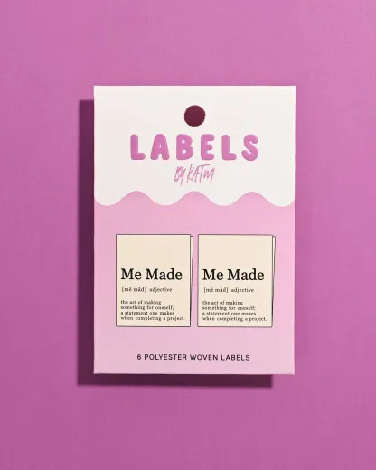 Verpackung Me Made Definition Verpackung des Kylie and The Machine Labels 'Me Made Definition' mit Wörterbuch-Design auf violettem Hintergrund