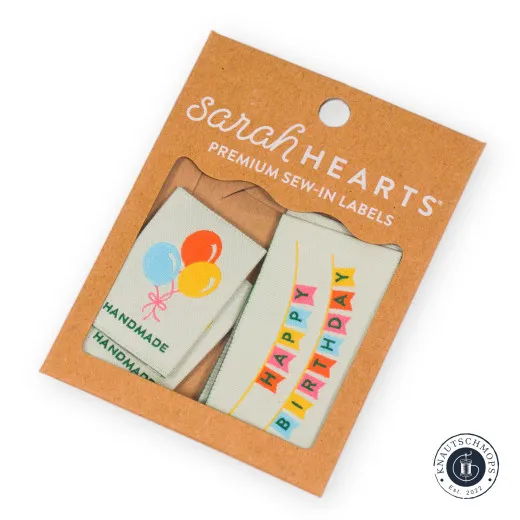 Verpackung mit Geburtstags-Labels Sarah Hearts Weblabel-Set „Birthday“ mit Luftballon- und „Happy Birthday“-Motiv, sichtbar durch das Fenster der Verpackung.